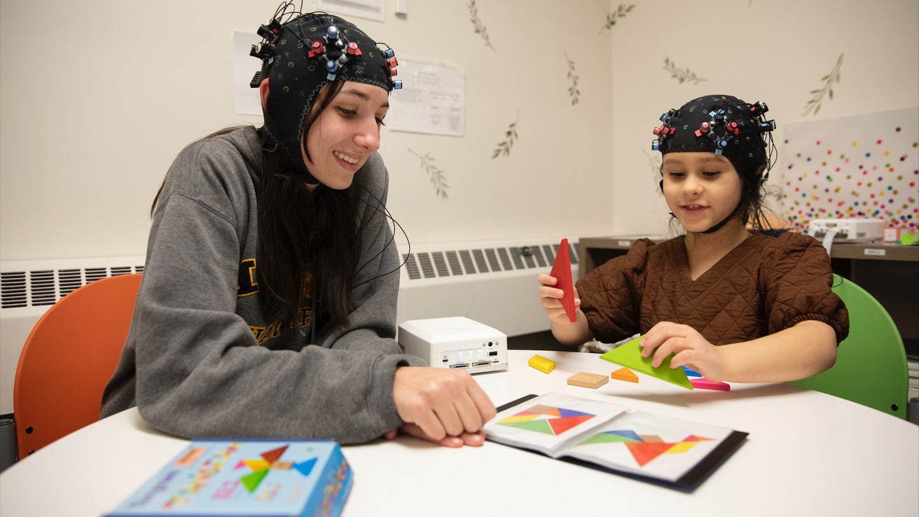 Child and adult undergoing simultaneous brain imaging while reading a book